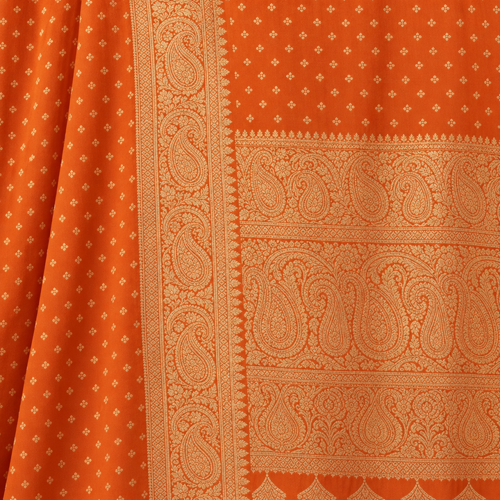 Close-up of the orange saree's wide gold woven zari border with paisley band and patterned pallu