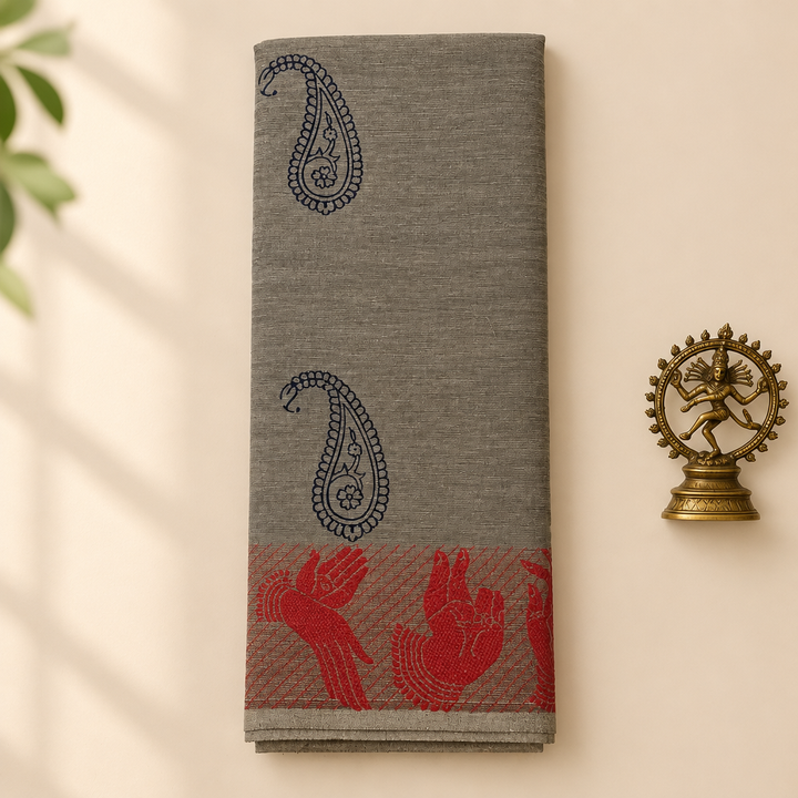 Grey cotton dance saree with navy paisleys and red bird motifs, folded flat lay with Nataraja prop