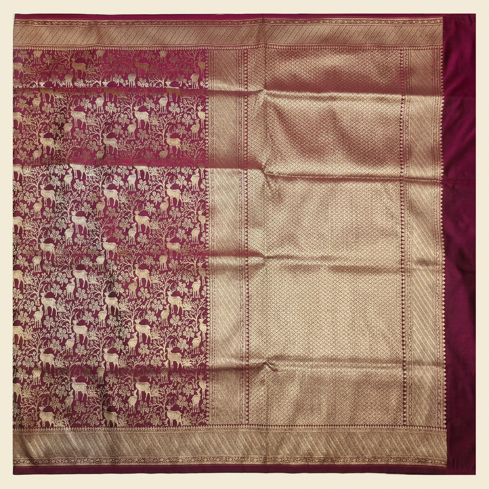 Straight overhead view of burgundy semi Banarasi saree with deer-and-vine motifs and gold-toned lattice pallu