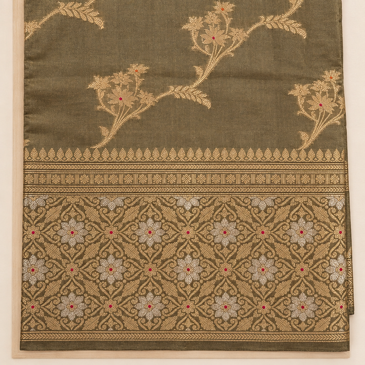 Close-up of ornate gold border on green saree