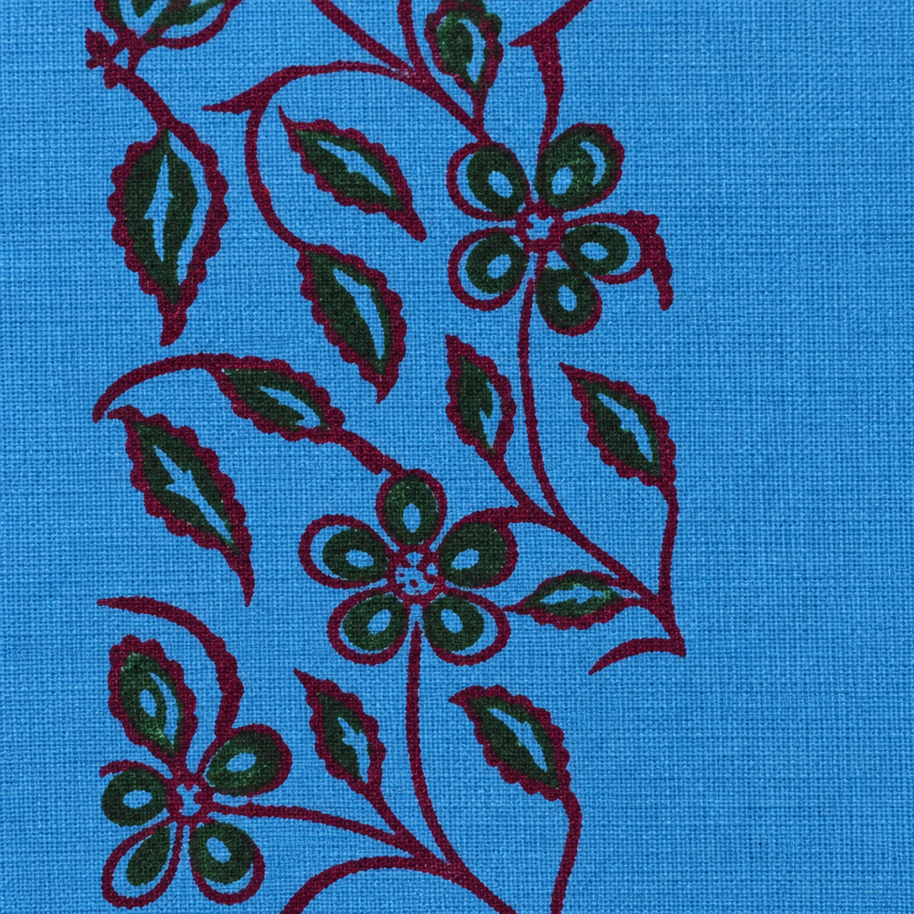 Close-up of green and maroon floral vine print on sky blue cotton saree