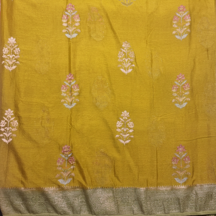 Close-up of floral buta with subtle pink accents on yellow-green body and pale metallic border