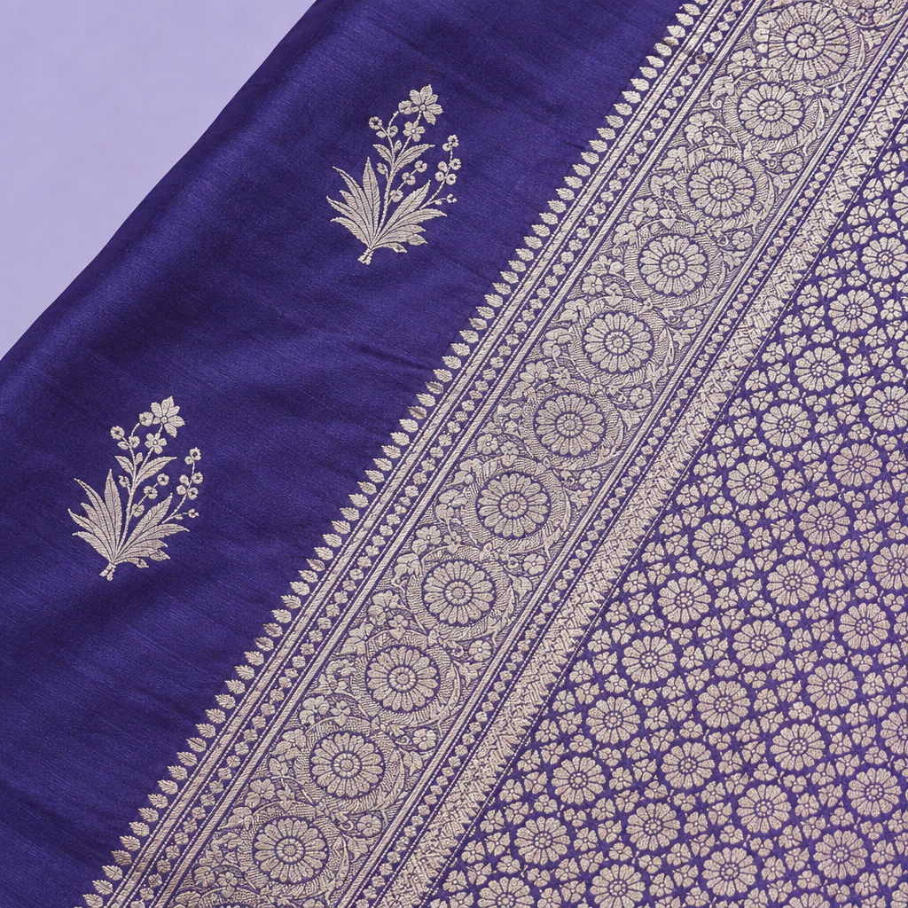 Close-up of the navy blue saree's wide woven silver zari border and patterned pallu