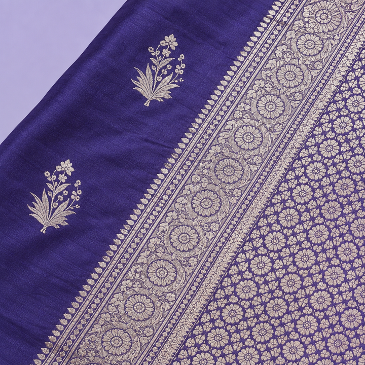 Close-up of the navy blue saree's wide woven silver zari border and patterned pallu