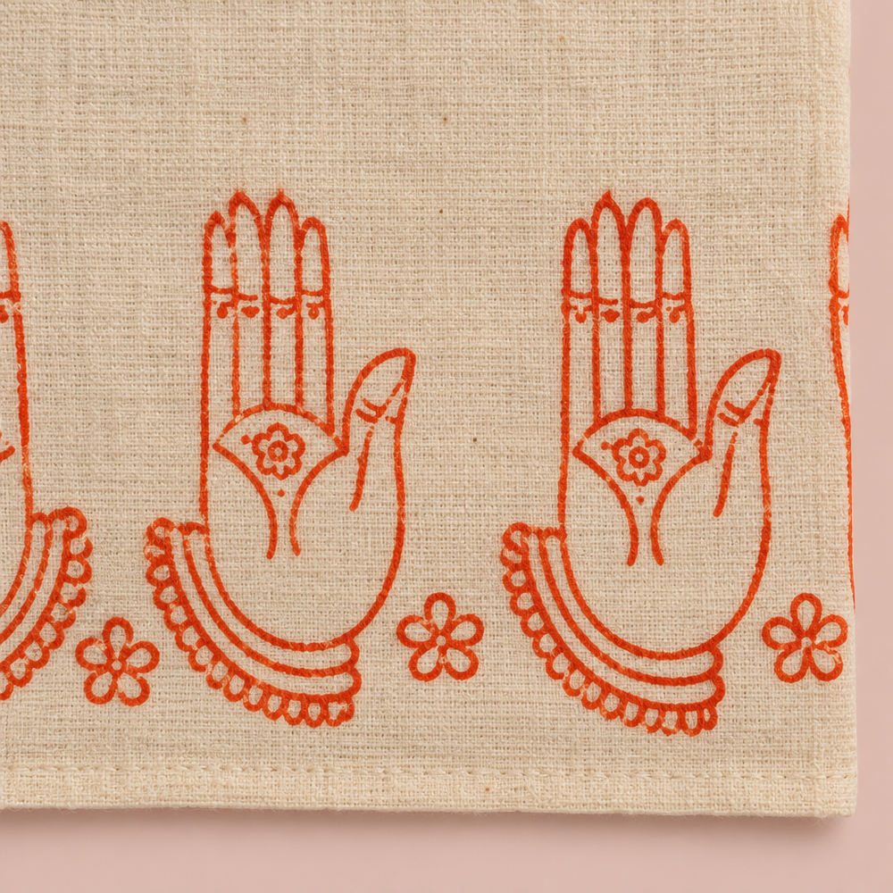 Close-up of orange hand-mudra print border on cream cotton dance saree