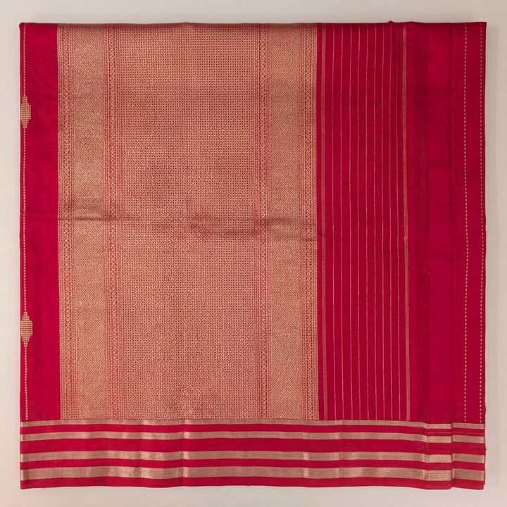 Close-up of gold-toned patterned pallu, striped pink end and parallel metallic-toned border bands