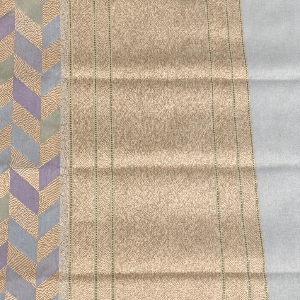 Pastel saree pallu close-up showing light gold-toned panel and pale edge