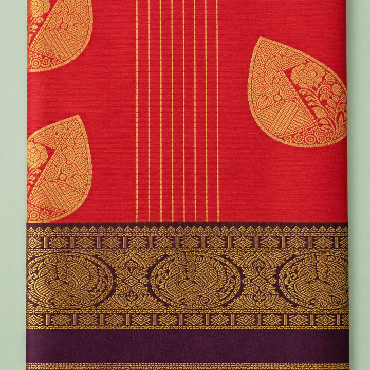 Close-up of orange and burgundy pure silk saree with gold paisley motifs, zari stripes, and brocade border