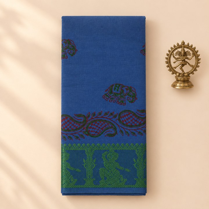 Royal blue cotton dance saree with paisley print and green border, folded flat lay with Nataraja prop