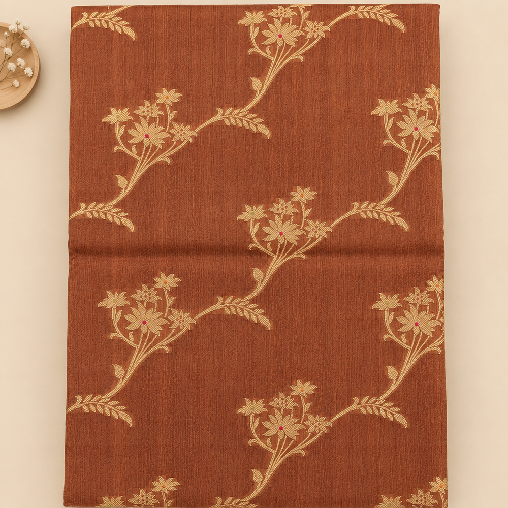 Close-up of gold floral vine motifs on brown saree