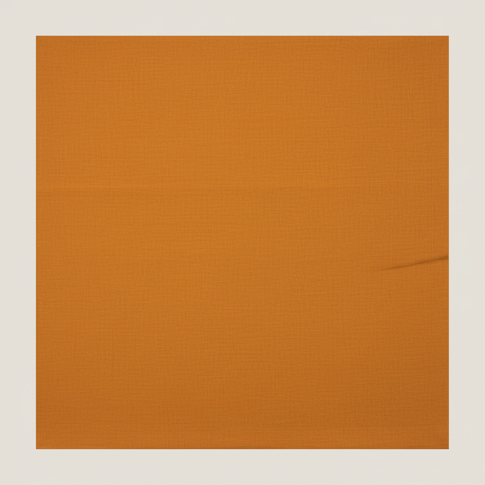 Close-up of the warm mustard-orange and ochre cotton saree showing its subtle woven texture