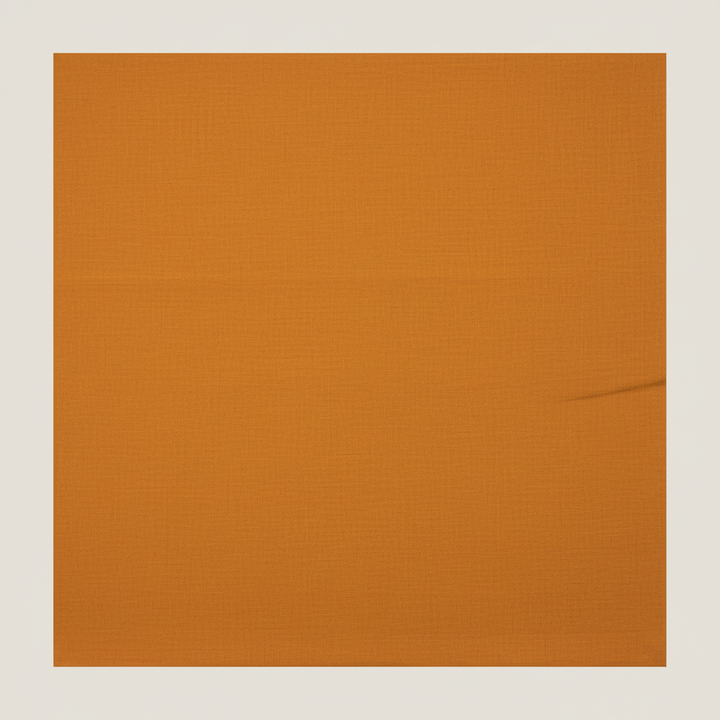 Close-up of the warm mustard-orange and ochre cotton saree showing its subtle woven texture