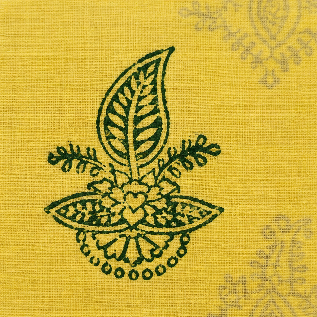 Close-up of dark green floral motif on pale yellow cotton saree