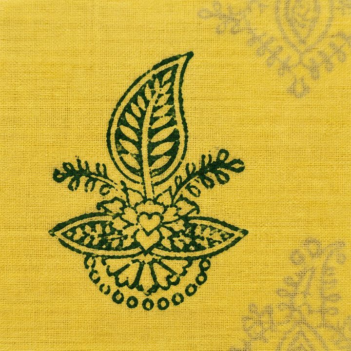 Close-up of dark green floral motif on pale yellow cotton saree