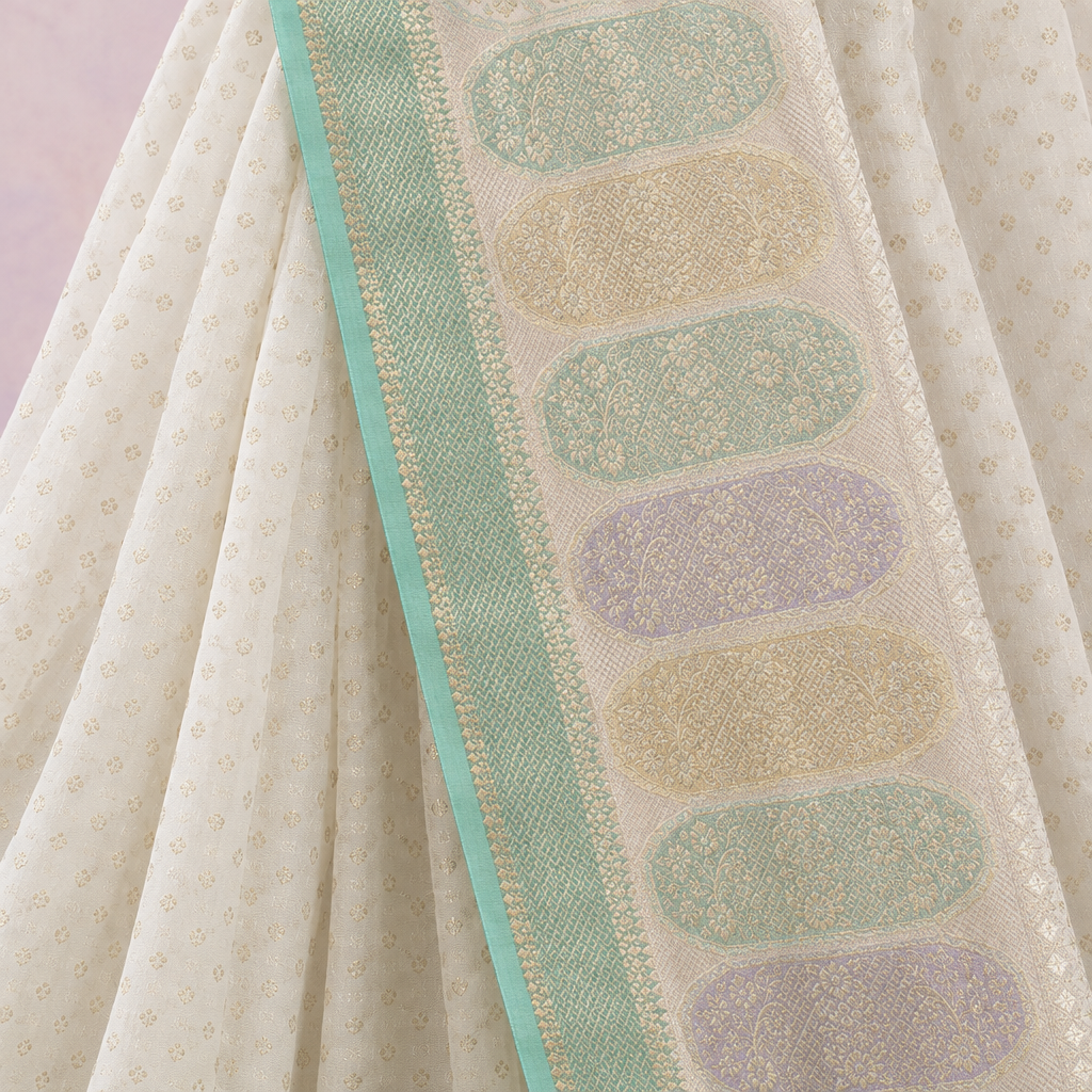 Close-up of the white saree's pastel woven pallu in mint, lilac, and gold with a mint green border