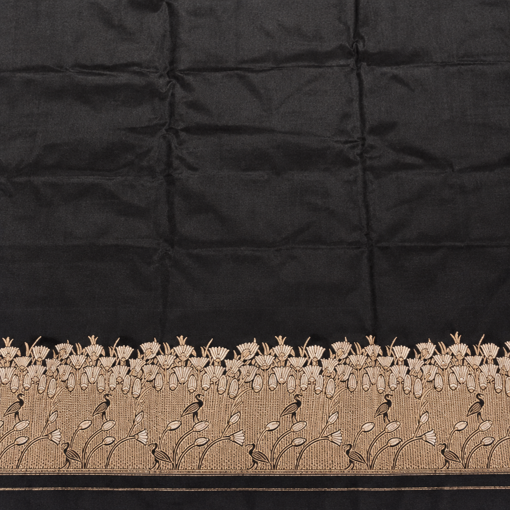 Plain black saree body above pale gold-toned botanical vines and floral border detailing