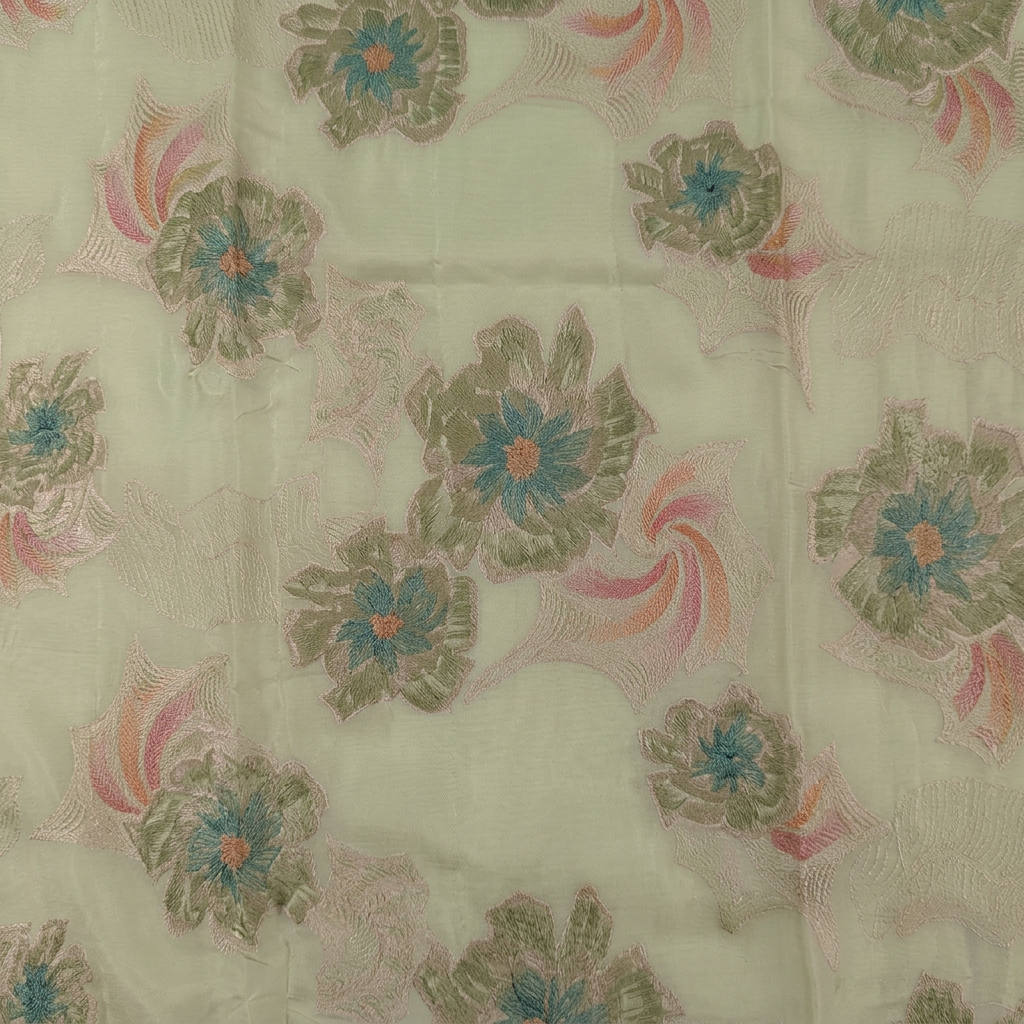 Close-up of muted green flowers with teal centres and peach-pink accents