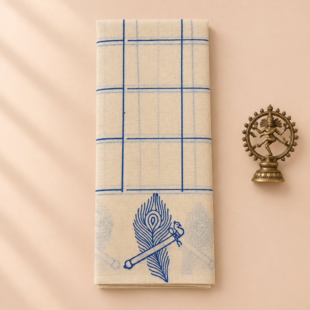 Cream cotton dance saree with blue checks and peacock feather flute border, folded flat lay with Nataraja prop