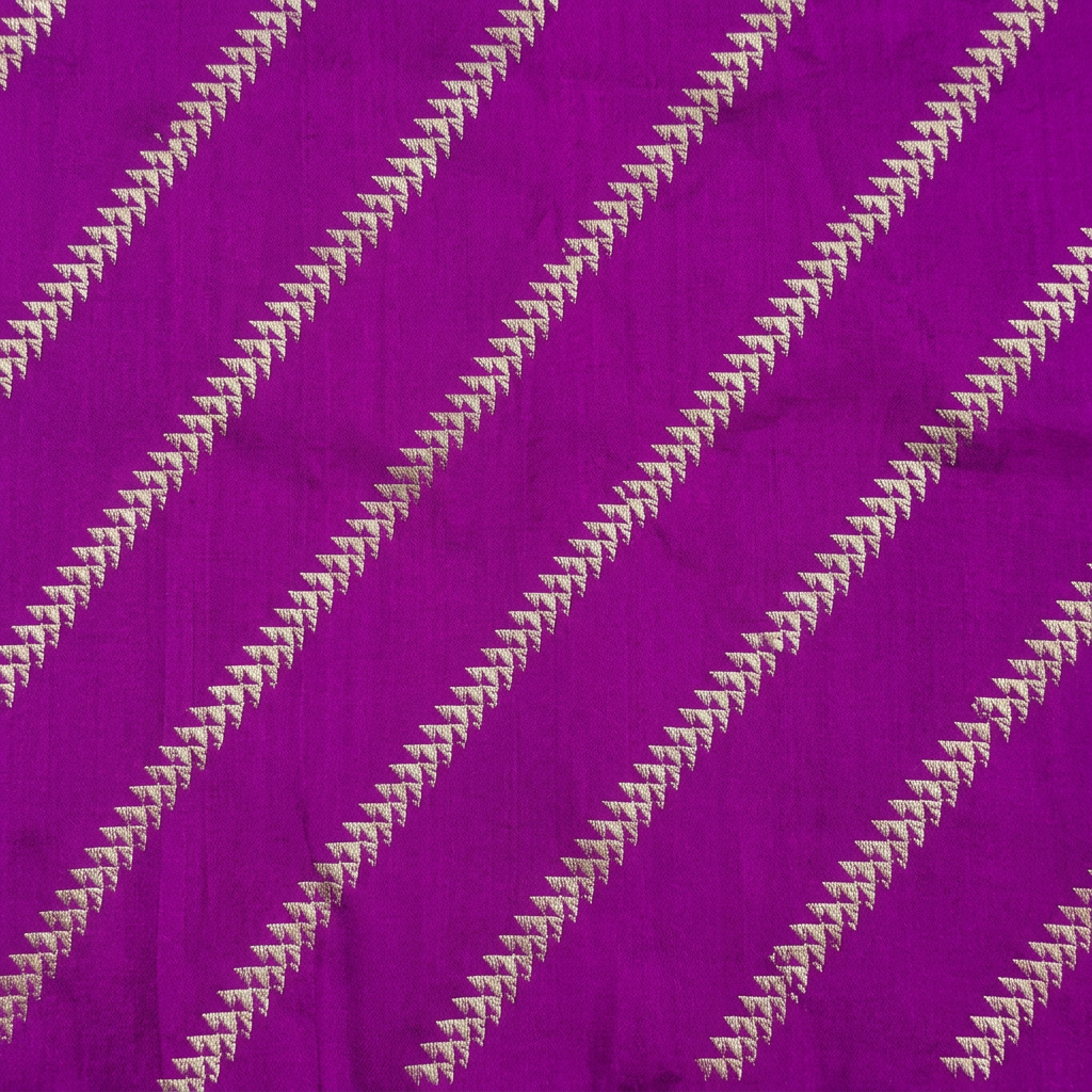 Close-up of diagonal rows of small metallic-toned geometric motifs on purple fabric