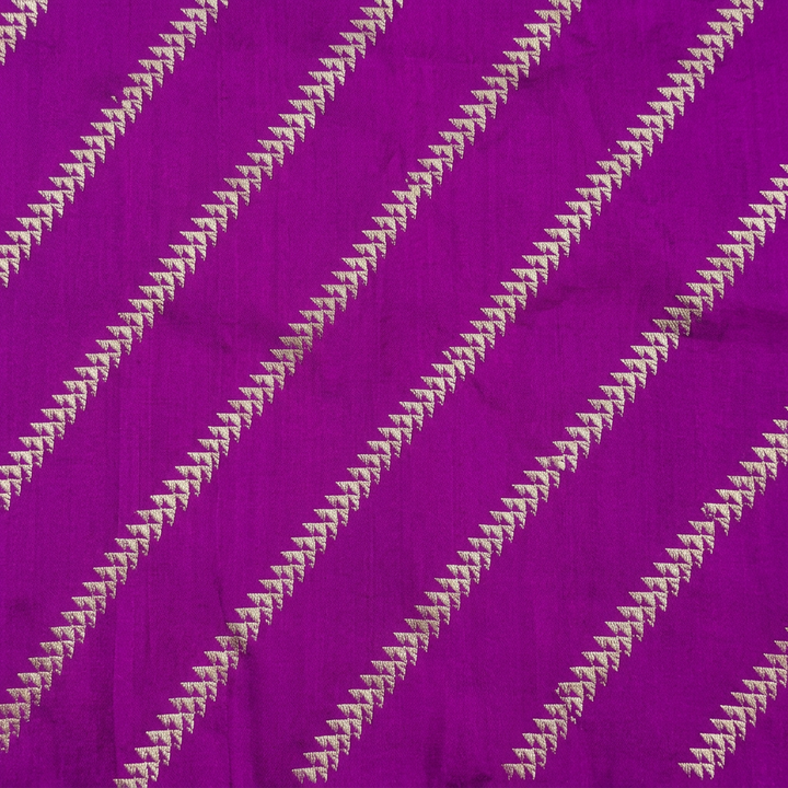 Close-up of diagonal rows of small metallic-toned geometric motifs on purple fabric