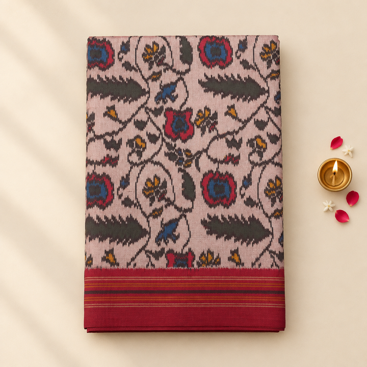 Grey pink Pochampally ikat silk saree folded on pastel background with brass diya