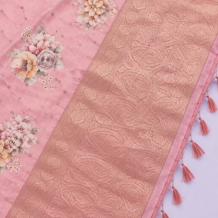 Close-up of the peach saree's wide rose-gold woven zari border and tasselled pallu