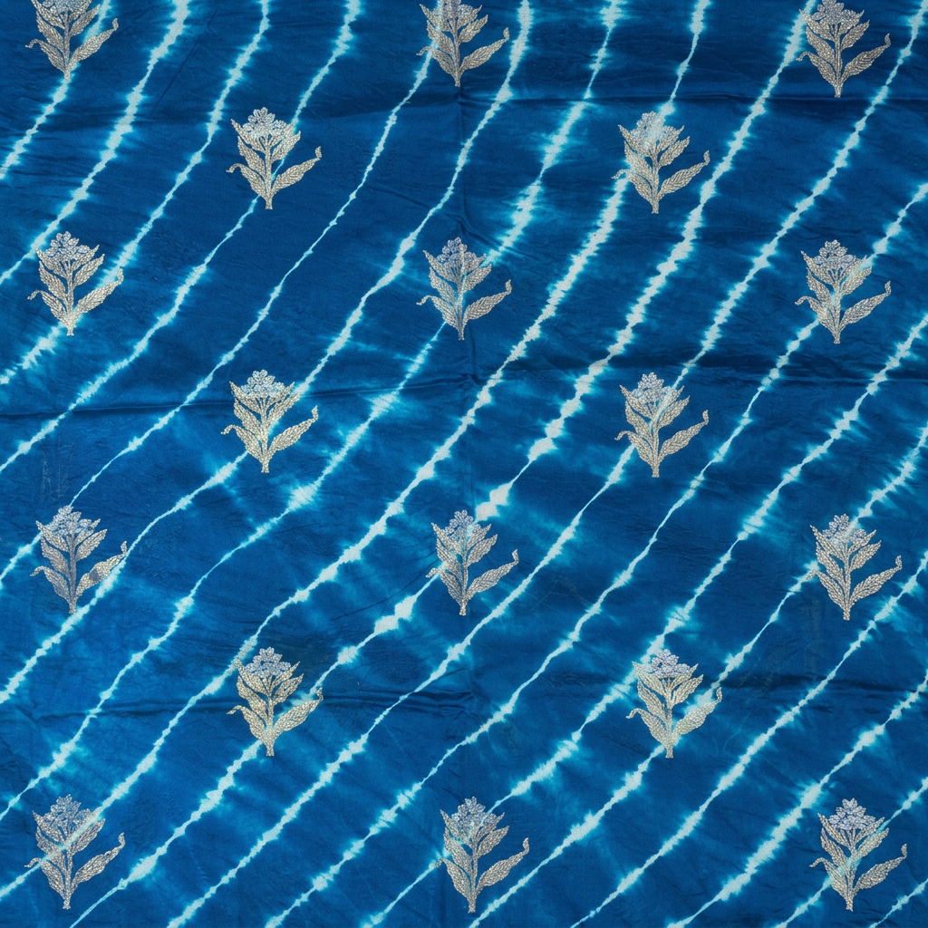 Close-up of pale diagonal Leheriya lines and floral sprigs on blue silk