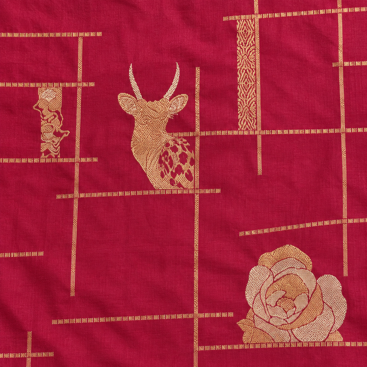 Magenta saree close-up showing gold-toned animal and floral motifs on lined body
