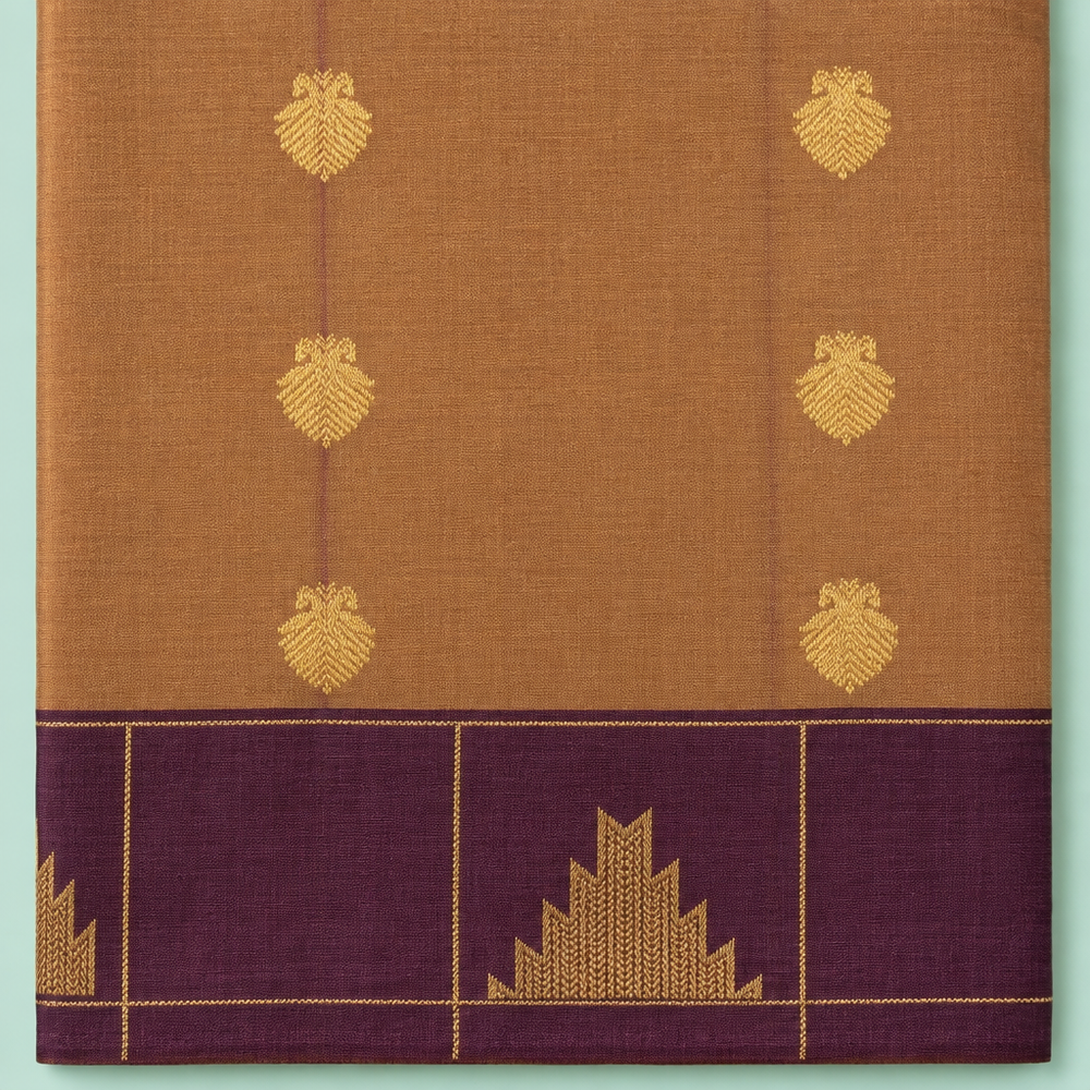 Close-up of brown and burgundy semi-silk saree with gold zari motifs and brocade border