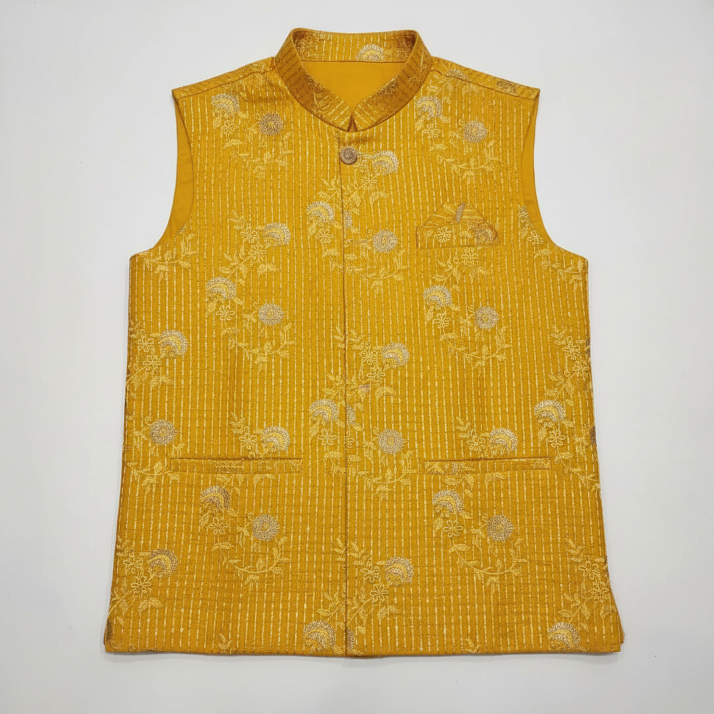 Close-up detail of yellow embroidered fabric with pin-tuck detailing