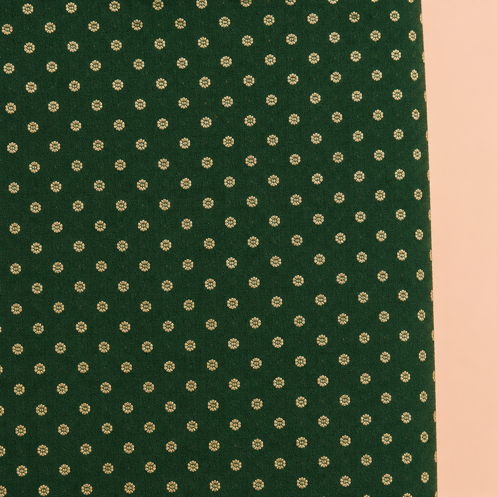 Close-up of the green saree body with small gold-tone motifs
