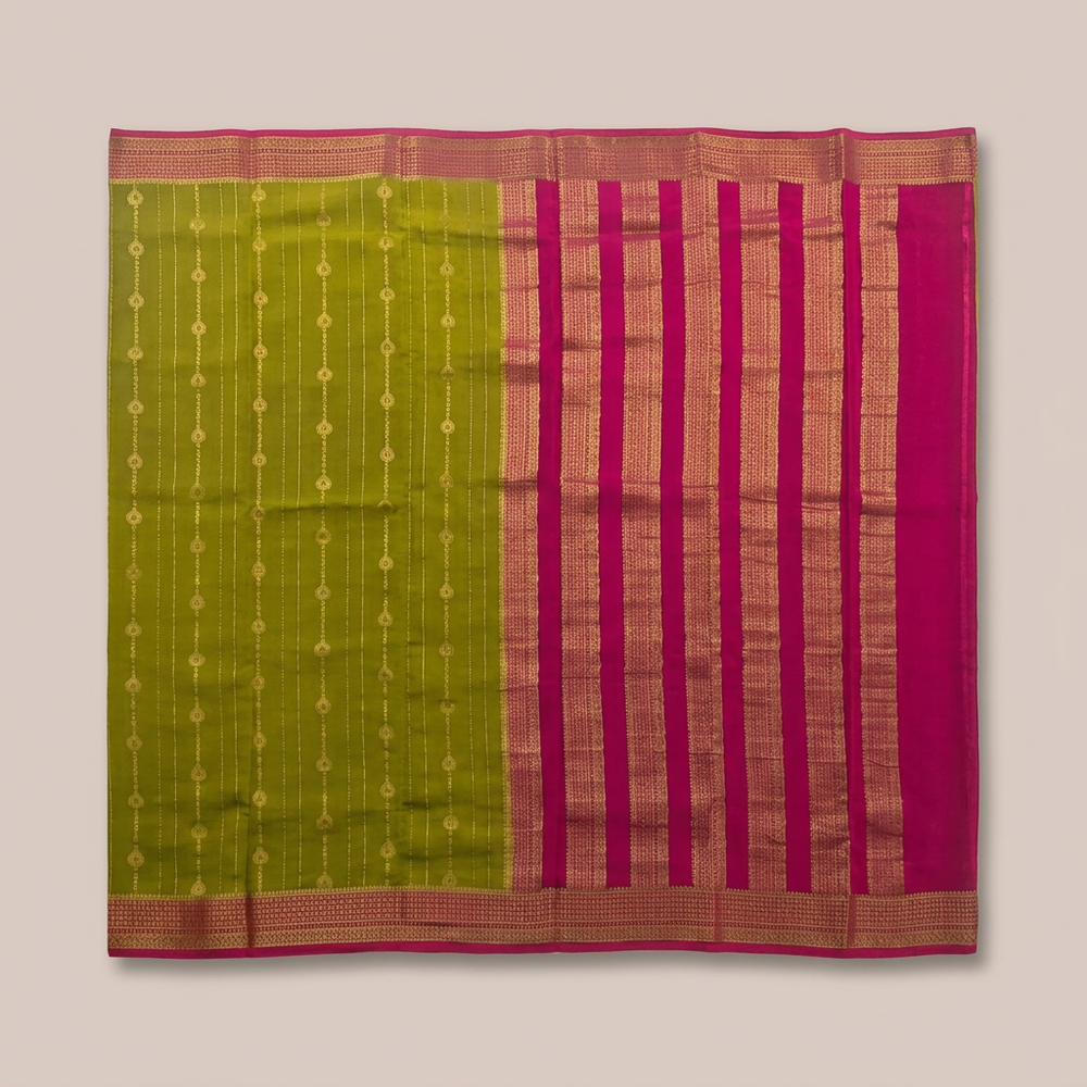 Upstraight overhead view of a green and pink pure Mysore crepe silk saree with dense gold zari bands and an ornate gold border