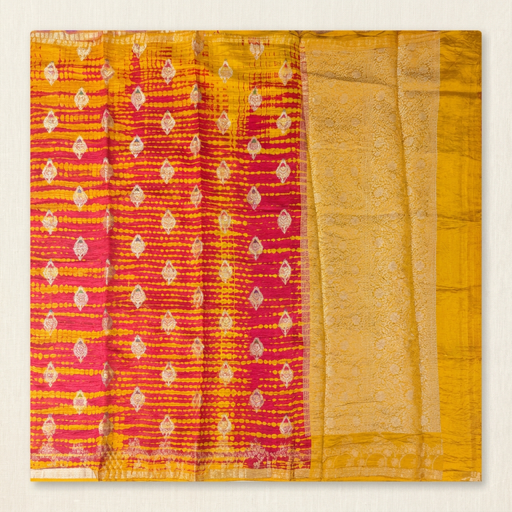 Full straight view of orange and yellow soft-crush Tussar silk saree with leaf motifs and gold-toned pallu