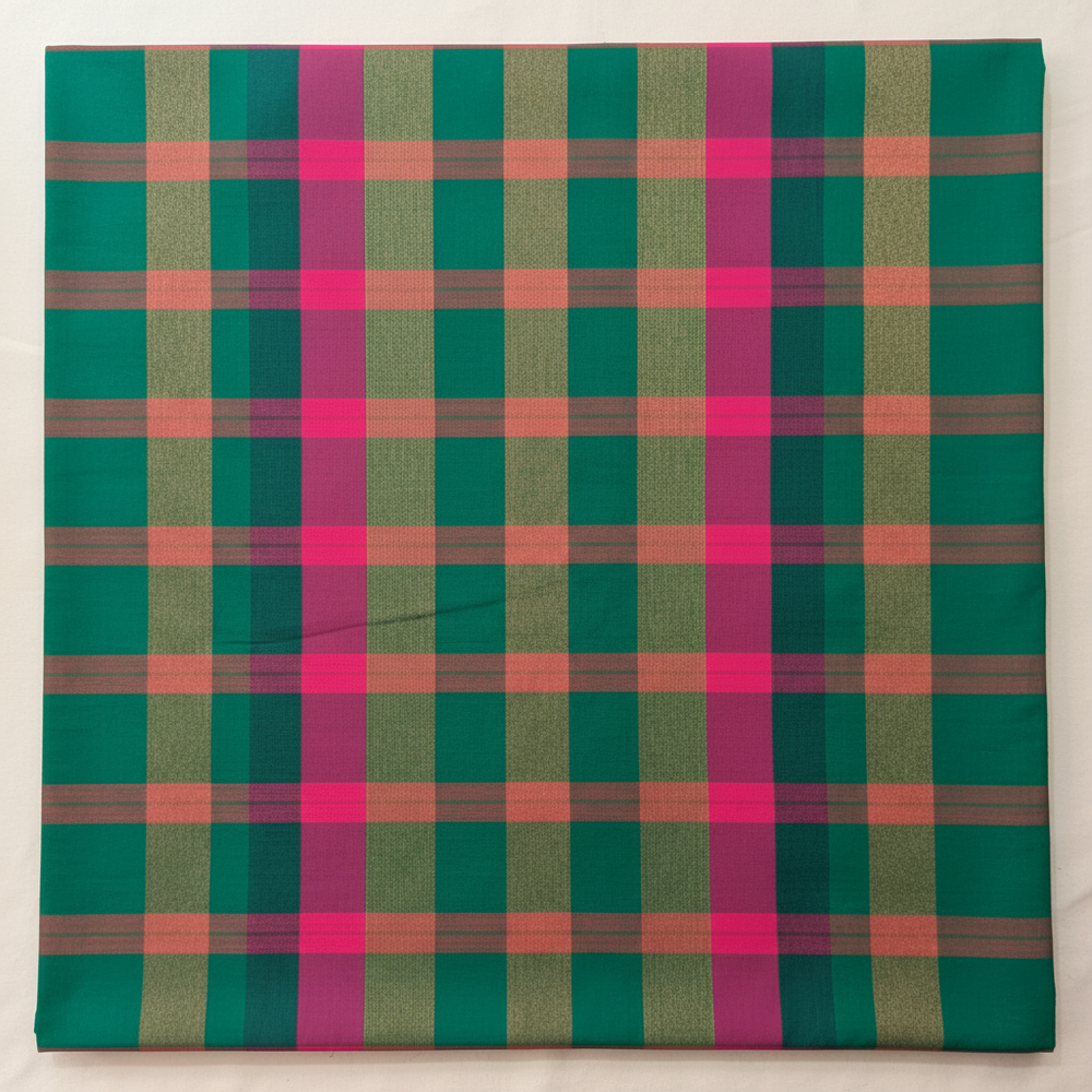 Close-up of the emerald-green cotton saree showing its muted taupe-brown and vivid hot-pink checked grid
