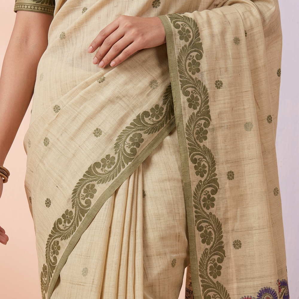 Pale cream-green saree with small olive motifs and scrolling olive floral border