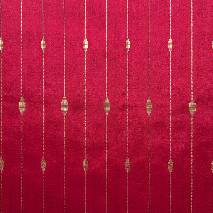 Close-up of fine metallic-toned vertical lines and geometric motifs on pink silk