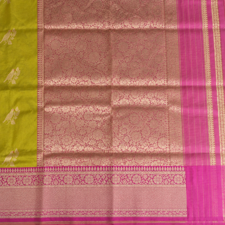 Rose-gold floral pallu and vivid pink border detail on green saree