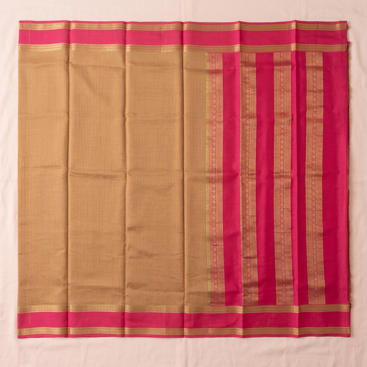 Upstraight overhead view of a pale brown and rani pink pure Mysore crepe silk saree with gold zari bands and pink gold-striped borders