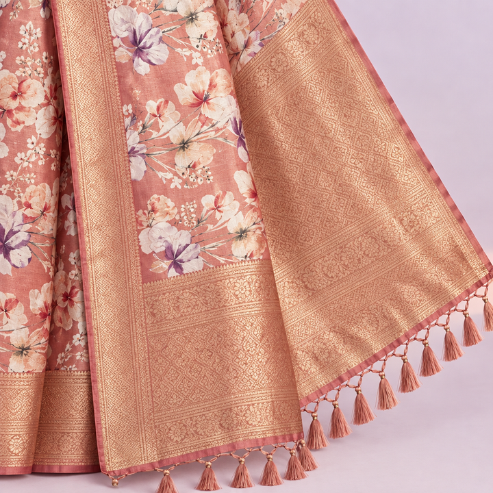 Close-up of the pink saree's wide golden zari border and tasselled patterned pallu
