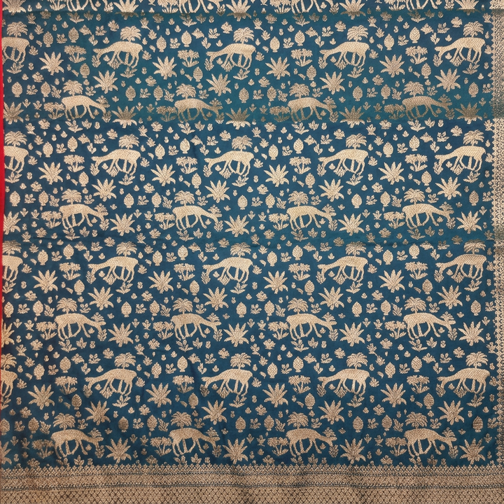 Close-up of blue saree body with metallic animal figures, leaves, buds and flowers