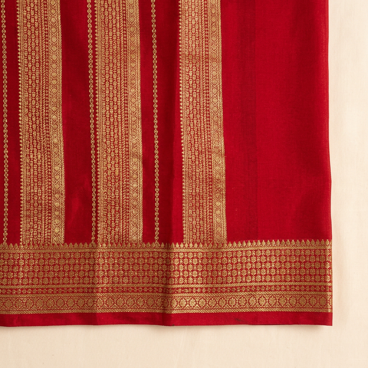 Close-up of the red contrast section with dense gold zari woven bands and ornate gold border