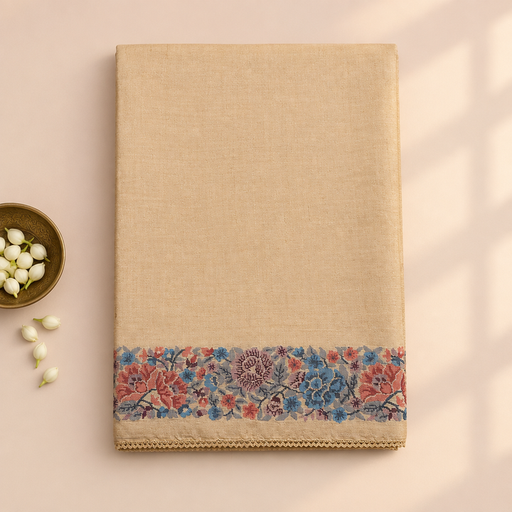 Kuberan beige pure Tussar silk saree folded upright on a pastel background with jasmine buds