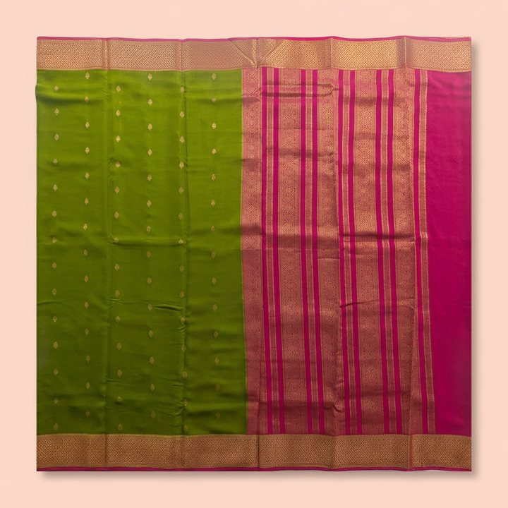 Upstraight overhead view of a green and pink pure Mysore crepe silk saree with gold butta motifs, magenta zari bands and gold border