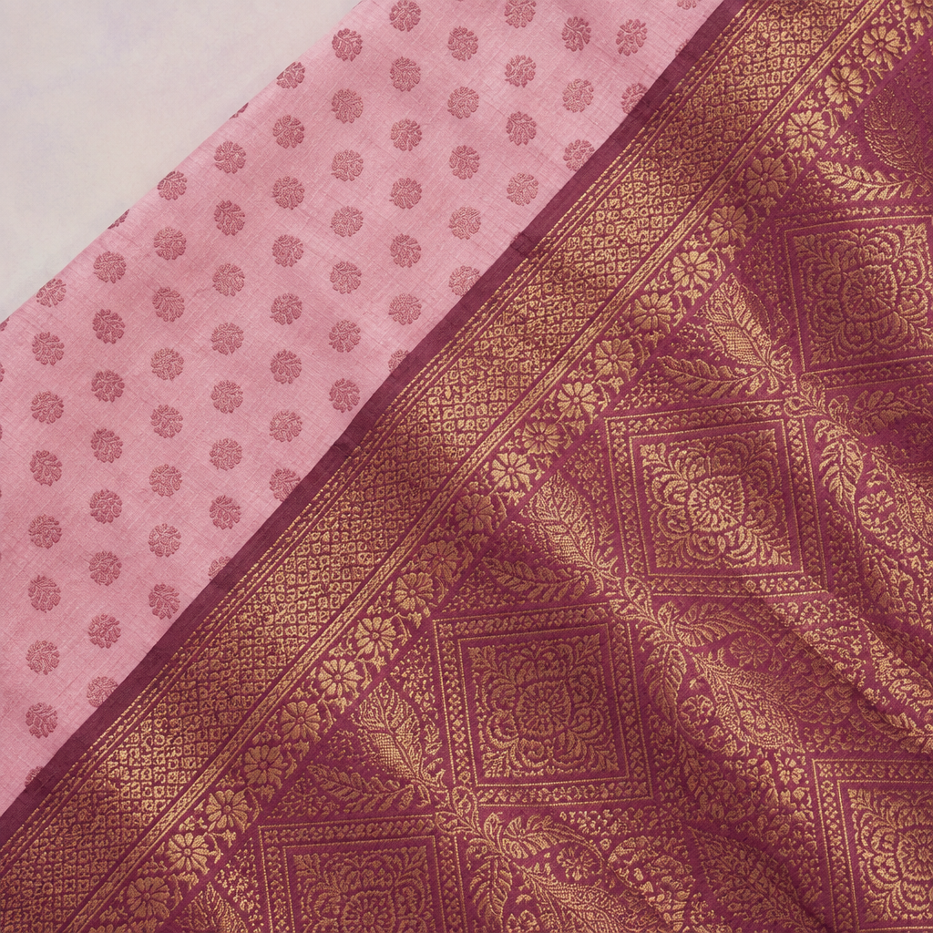 Close-up of the pink saree's wide wine-red woven zari border and patterned pallu