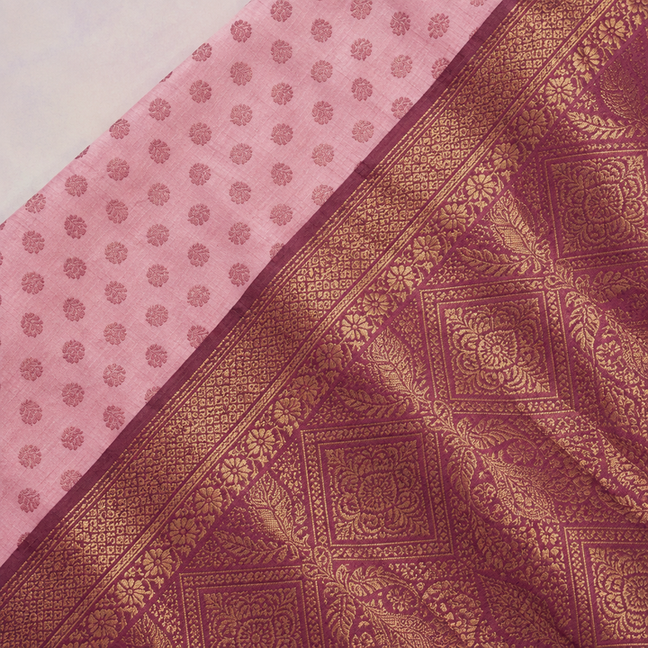 Close-up of the pink saree's wide wine-red woven zari border and patterned pallu
