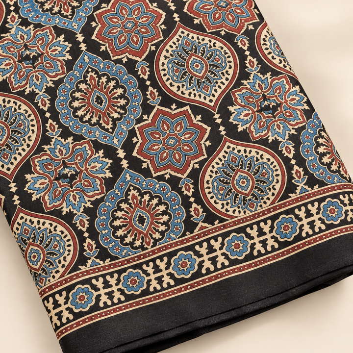 Folded close-up of indigo Ajrakh saree ornate floral motifs and border