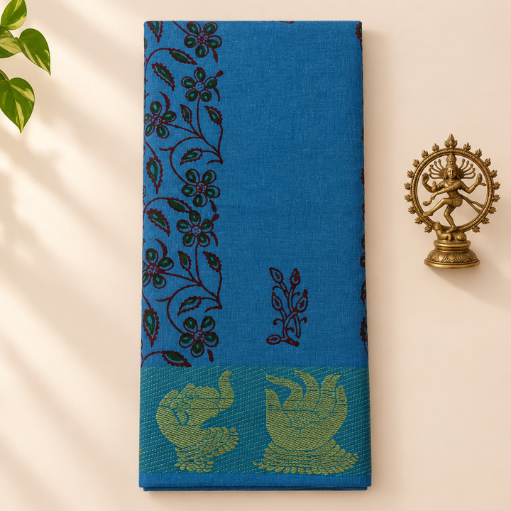 Sky blue cotton dance saree with green elephant motifs, folded flat lay with Nataraja prop