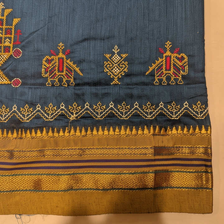 Close-up of the mustard-gold zari border with Kasuti peacock motifs and temple teeth