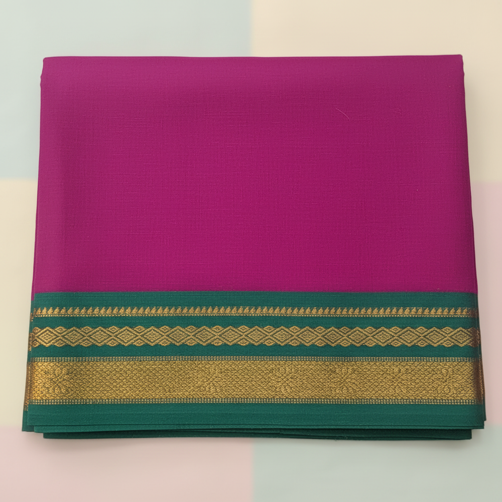 Close-up of the magenta saree showing its deep teal-green border bands, layered antique-gold motifs, and teal-green lower edge