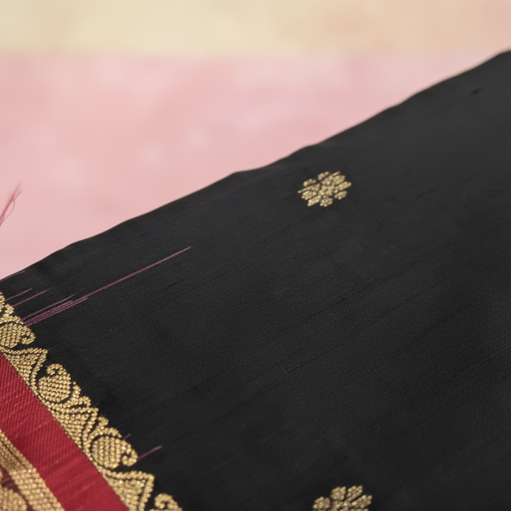 Close-up of gold zari butta motifs on black pure silk Kanchipuram saree body